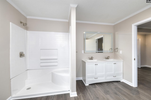 bathroom featuring a textured ceiling, ornamental molding, and walk in shower