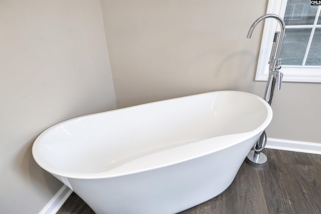 bathroom with a bathtub and hardwood / wood-style flooring