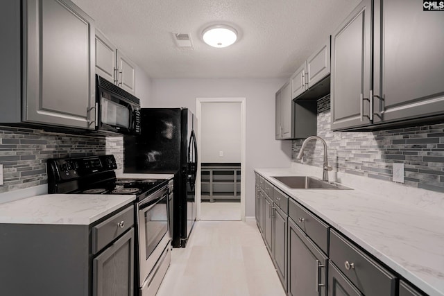 kitchen with light stone countertops, sink, range with electric stovetop, a textured ceiling, and gray cabinets