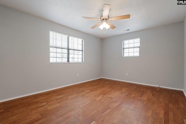 empty room featuring ceiling fan, a textured ceiling, and hardwood / wood-style flooring