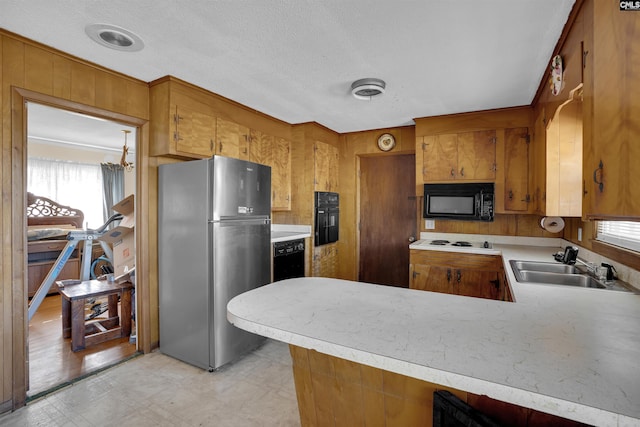 kitchen featuring black appliances, kitchen peninsula, and sink