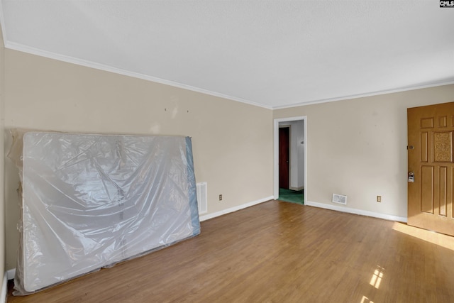 unfurnished room with hardwood / wood-style flooring and ornamental molding