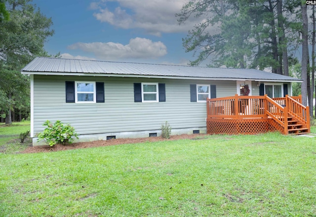 rear view of property featuring a lawn and a wooden deck