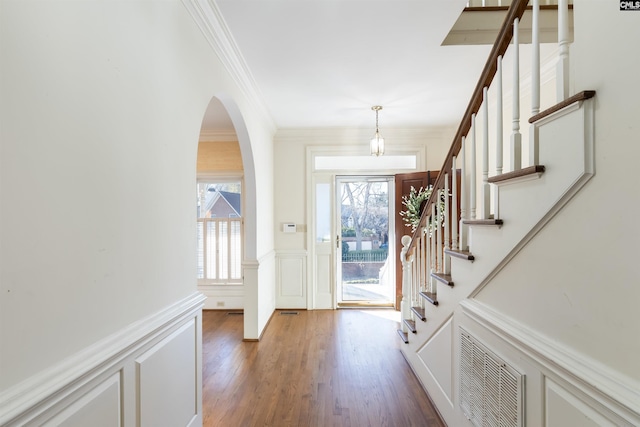 entrance foyer with dark hardwood / wood-style flooring and crown molding