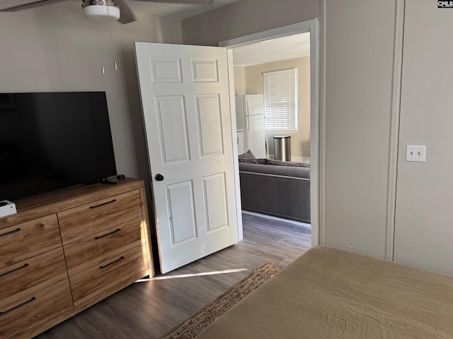 bedroom with ceiling fan, light hardwood / wood-style floors, and white refrigerator