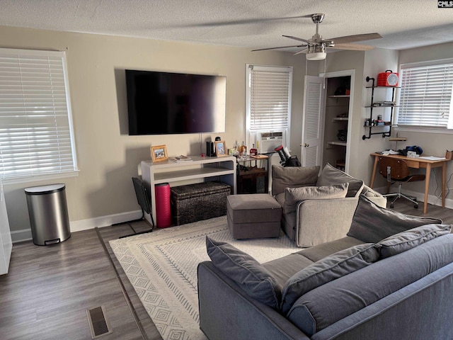 living room with wood-type flooring, a textured ceiling, ceiling fan, and cooling unit