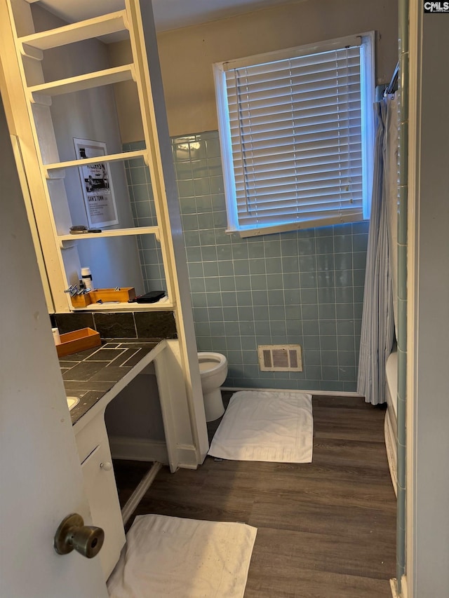 full bathroom with shower / bath combo, vanity, hardwood / wood-style flooring, and toilet