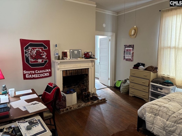 bedroom featuring dark hardwood / wood-style flooring, ornamental molding, and a fireplace