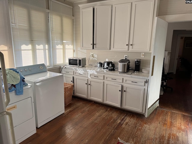 laundry area with dark wood-type flooring and washing machine and clothes dryer