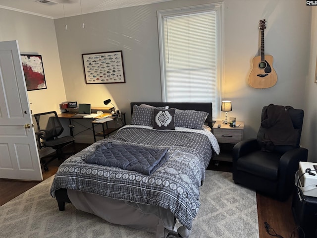 bedroom featuring wood-type flooring and ornamental molding