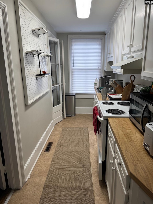 kitchen featuring white electric range oven, white cabinets, and wooden counters