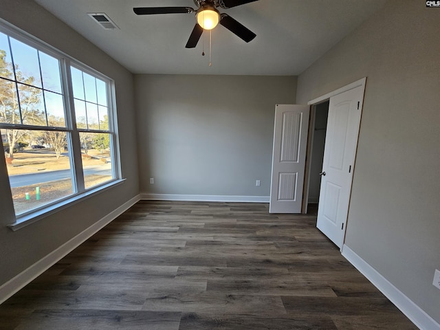 empty room featuring ceiling fan and dark wood-type flooring