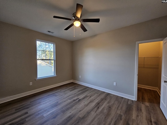 empty room with ceiling fan and dark wood-type flooring