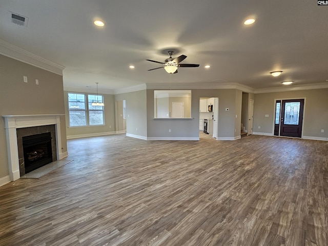 unfurnished living room featuring hardwood / wood-style floors, ceiling fan, crown molding, and a tile fireplace