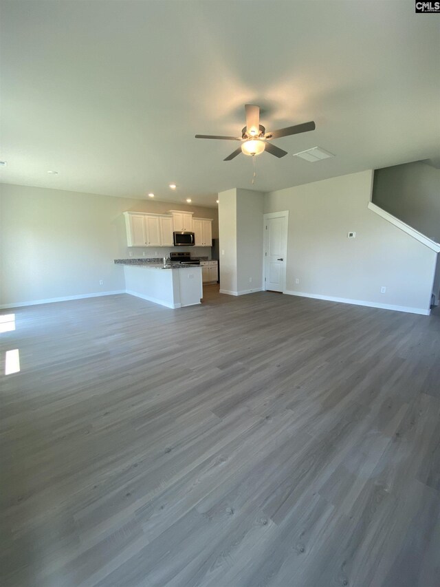 unfurnished living room featuring ceiling fan and wood-type flooring