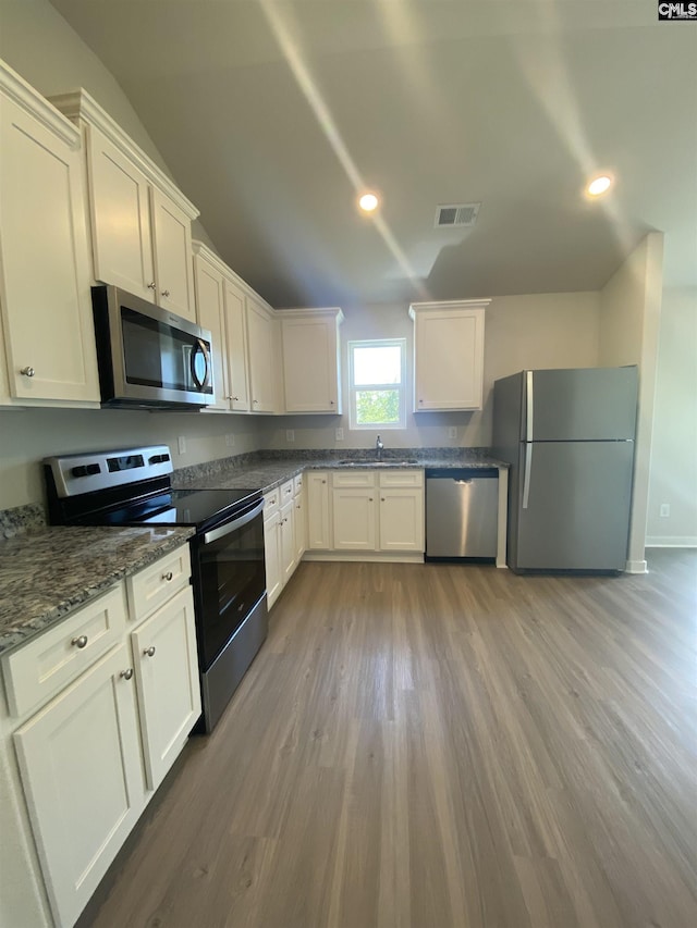 kitchen with light wood finished floors, visible vents, white cabinets, appliances with stainless steel finishes, and a sink