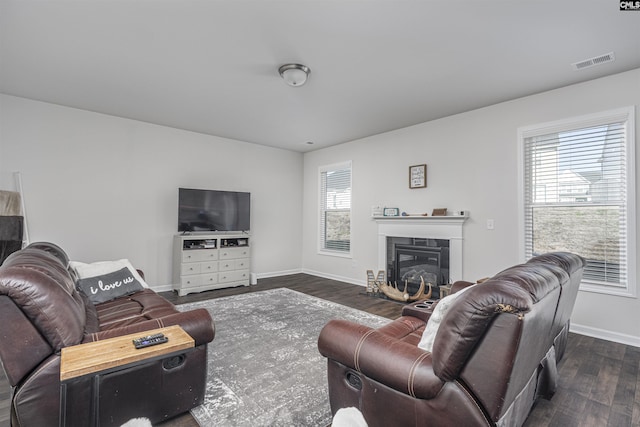 living room featuring a wealth of natural light and dark wood-type flooring