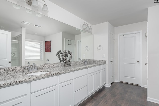 bathroom featuring hardwood / wood-style flooring, vanity, and an enclosed shower