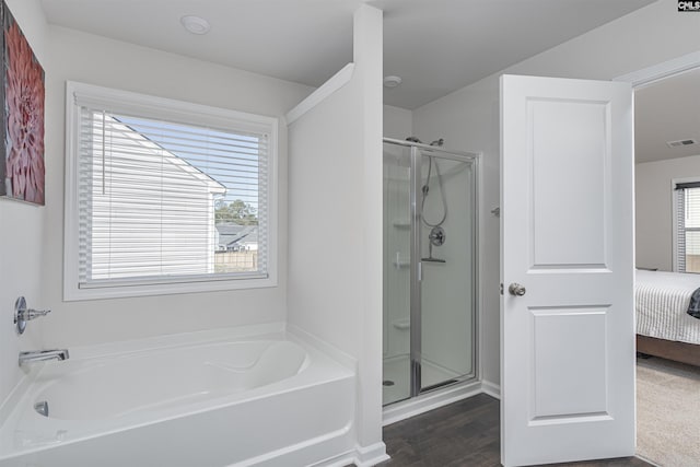 bathroom with plenty of natural light, wood-type flooring, and independent shower and bath