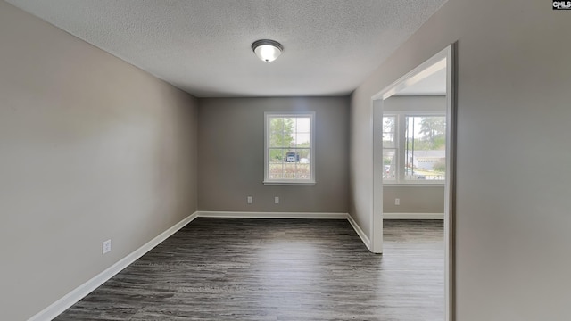 spare room with dark hardwood / wood-style flooring and a textured ceiling