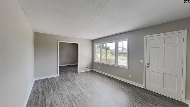 unfurnished room featuring a textured ceiling and dark wood-type flooring