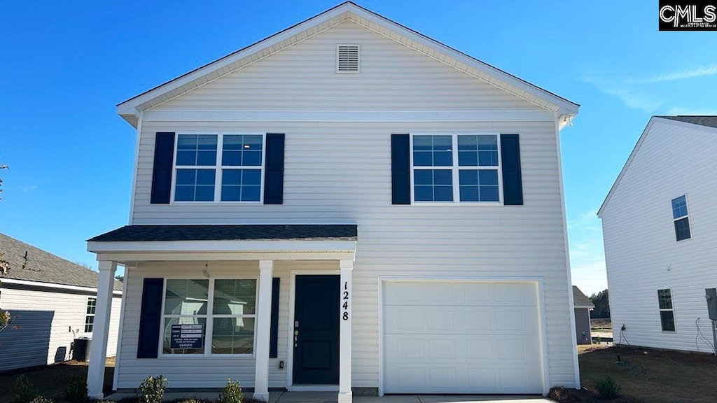 view of property featuring covered porch and a garage