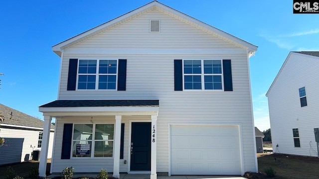 view of property featuring covered porch and a garage