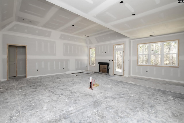 unfurnished living room with baseboards