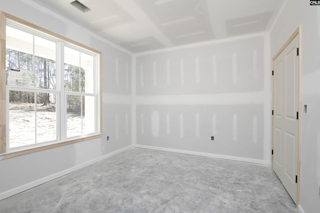 spare room featuring concrete floors and baseboards