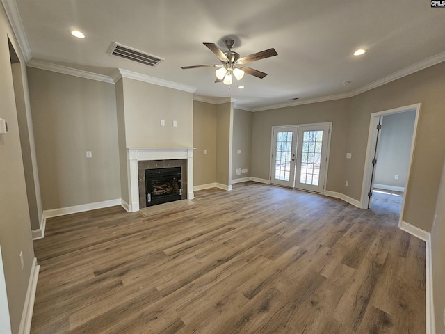 unfurnished living room featuring a tile fireplace, french doors, hardwood / wood-style flooring, and ornamental molding