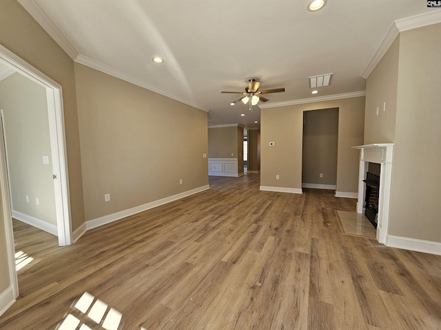 unfurnished living room with a tiled fireplace, ceiling fan, light hardwood / wood-style floors, and ornamental molding