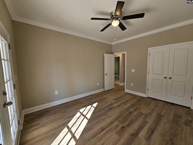 unfurnished bedroom featuring dark wood-type flooring, a closet, ceiling fan, and crown molding