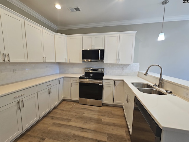 kitchen with decorative light fixtures, sink, white cabinetry, and stainless steel appliances