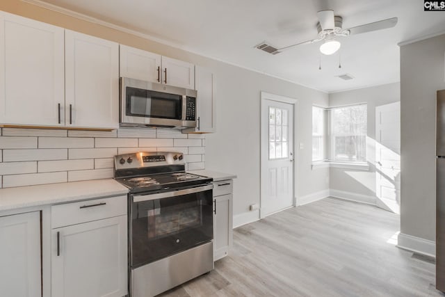 kitchen featuring white cabinetry, ceiling fan, tasteful backsplash, light hardwood / wood-style flooring, and appliances with stainless steel finishes