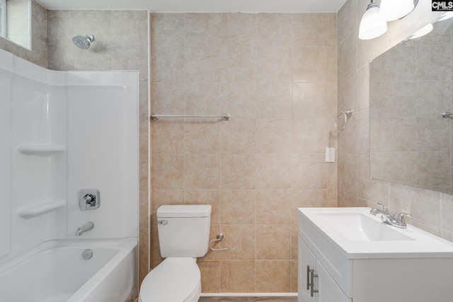 full bathroom featuring vanity, bathing tub / shower combination, toilet, and tile walls