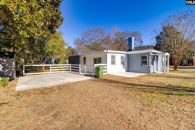 back of house with a lawn and a patio area