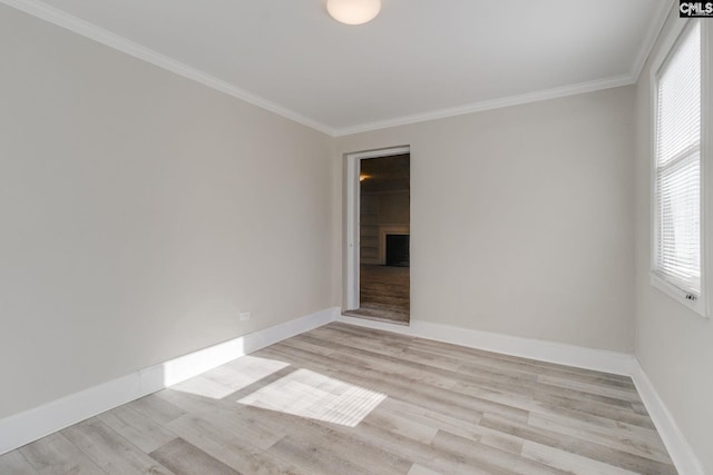 spare room with light wood-type flooring and ornamental molding