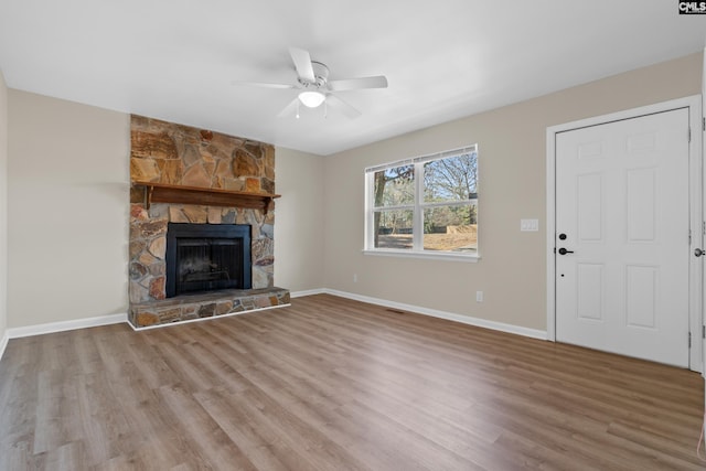 unfurnished living room with ceiling fan, a fireplace, and light hardwood / wood-style floors