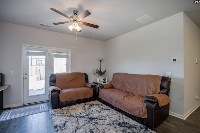 living room with ceiling fan and dark hardwood / wood-style flooring