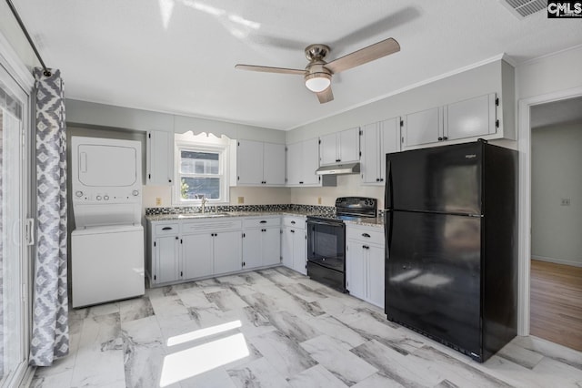 kitchen featuring stacked washer and dryer, white cabinets, black appliances, and sink