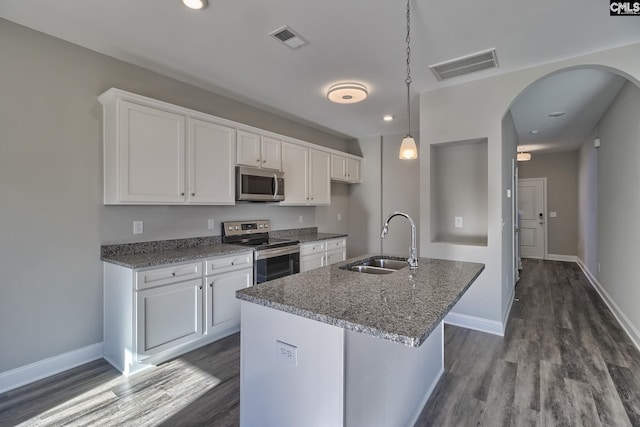 kitchen with a sink, stainless steel appliances, arched walkways, and visible vents