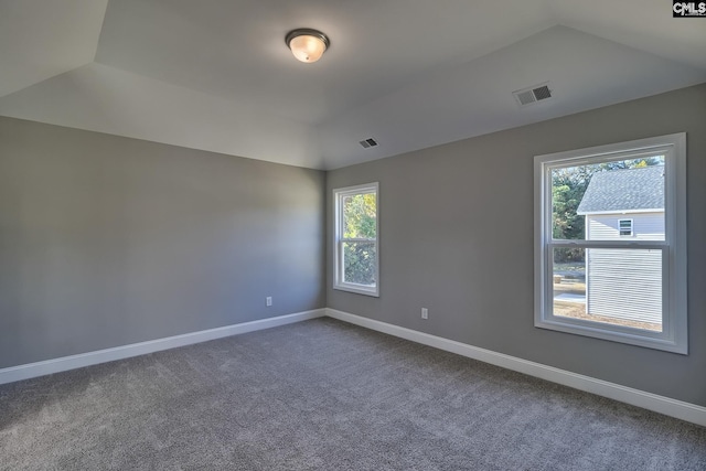 unfurnished room with visible vents, baseboards, and lofted ceiling