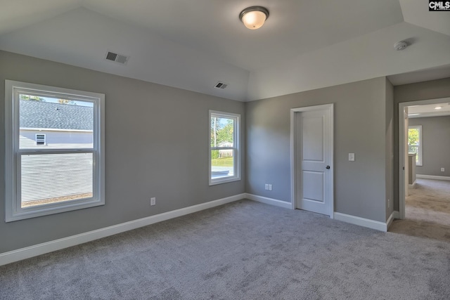 unfurnished bedroom featuring visible vents, light carpet, and vaulted ceiling