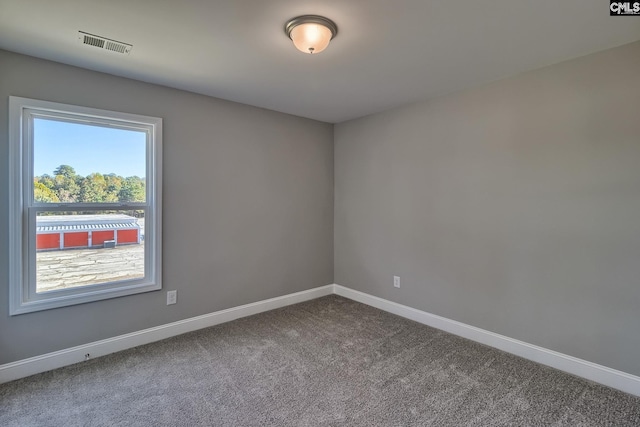 carpeted spare room with visible vents and baseboards