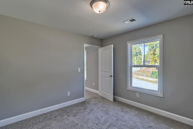 unfurnished room featuring visible vents, baseboards, and carpet flooring