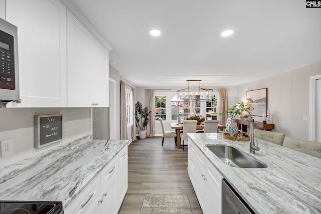 kitchen with white cabinets, light stone countertops, and sink