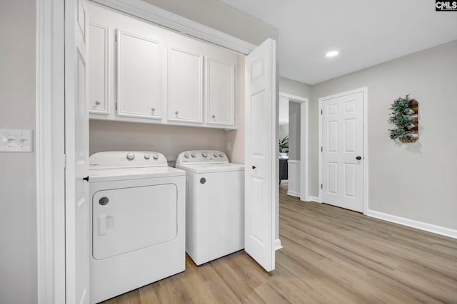 clothes washing area featuring light hardwood / wood-style floors, cabinets, and washing machine and clothes dryer