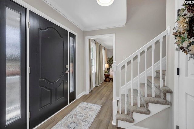 entrance foyer with ornamental molding and light wood-type flooring