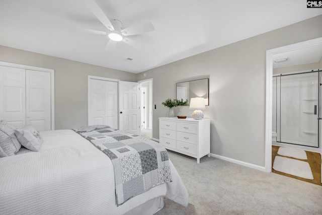 carpeted bedroom with ceiling fan and multiple closets