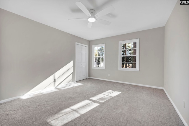 carpeted spare room featuring ceiling fan